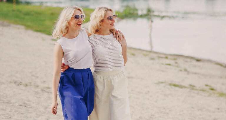 Healthy Young Adult twins walk the beach